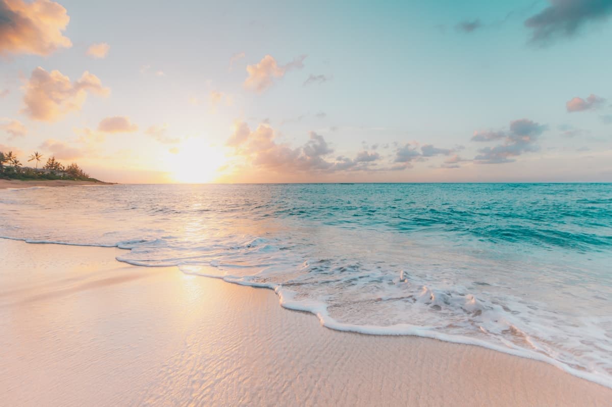Calm turquoise ocean and sandy beach from above
